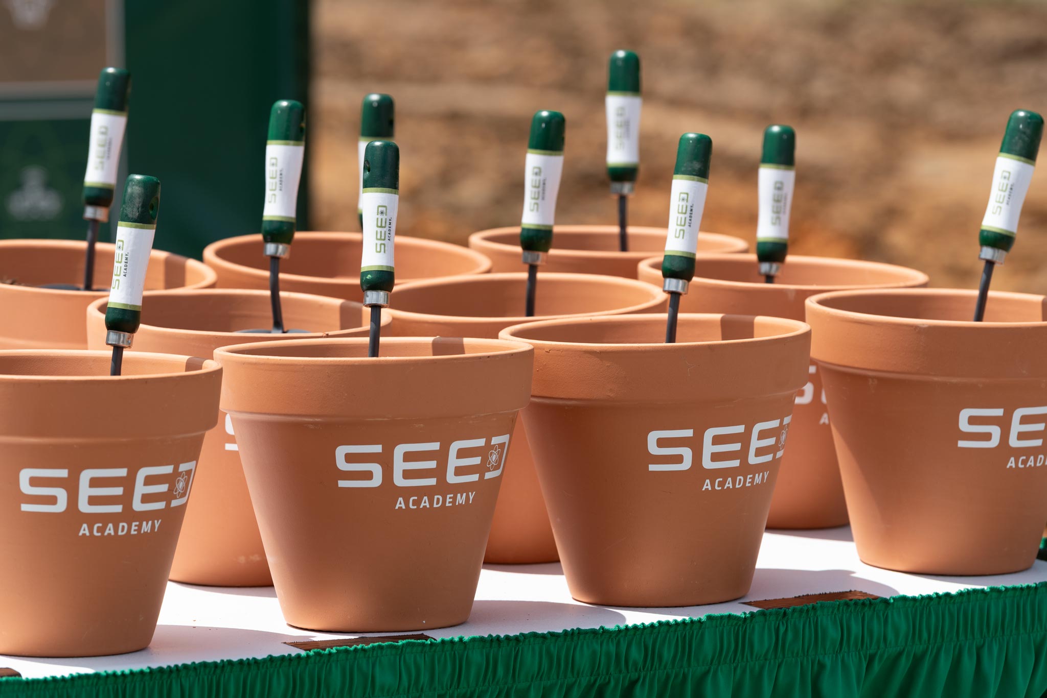 Pots and spades with the "SEED ACADEMY" logo