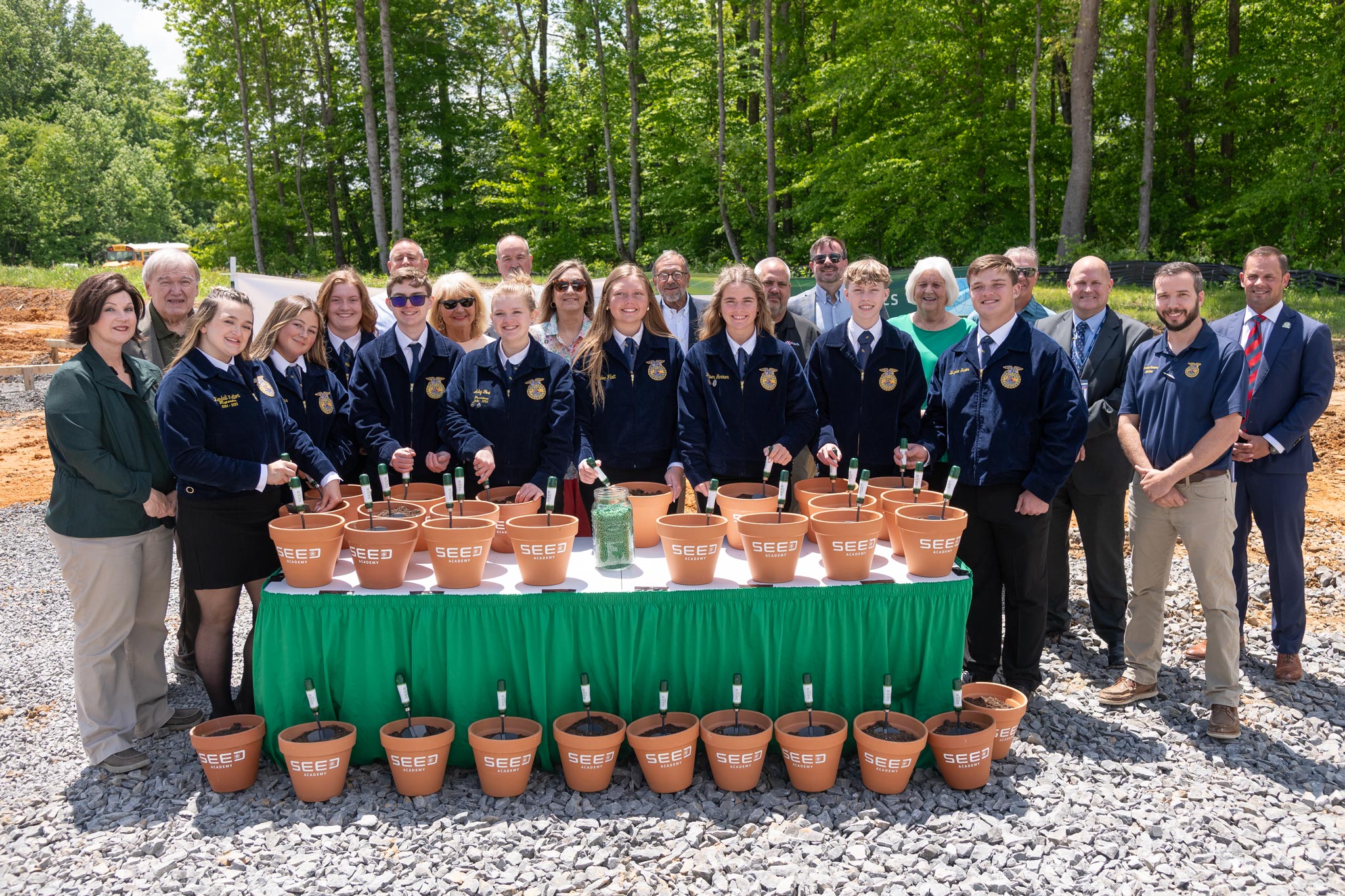Adults and students at table with seed pots