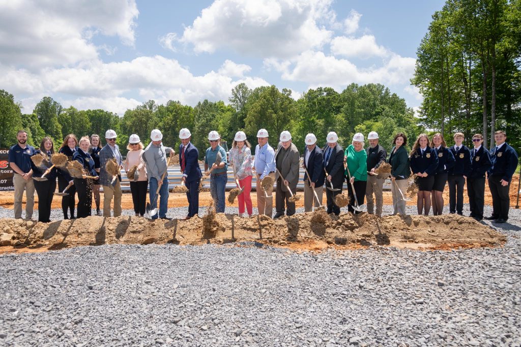 people shoveling dirt at groundbreaking