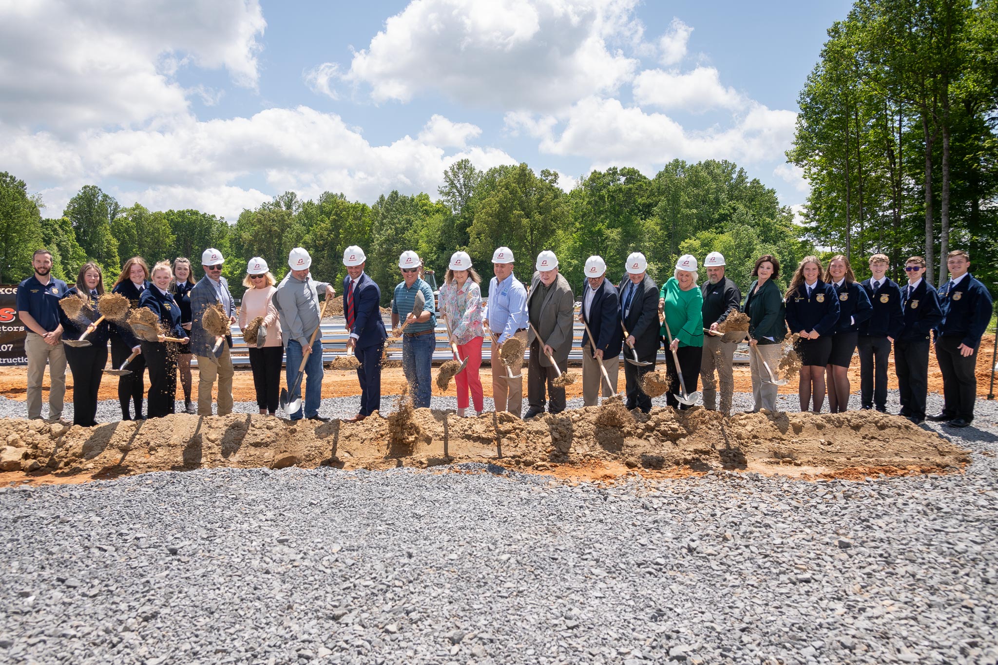 people shoveling dirt at groundbreaking