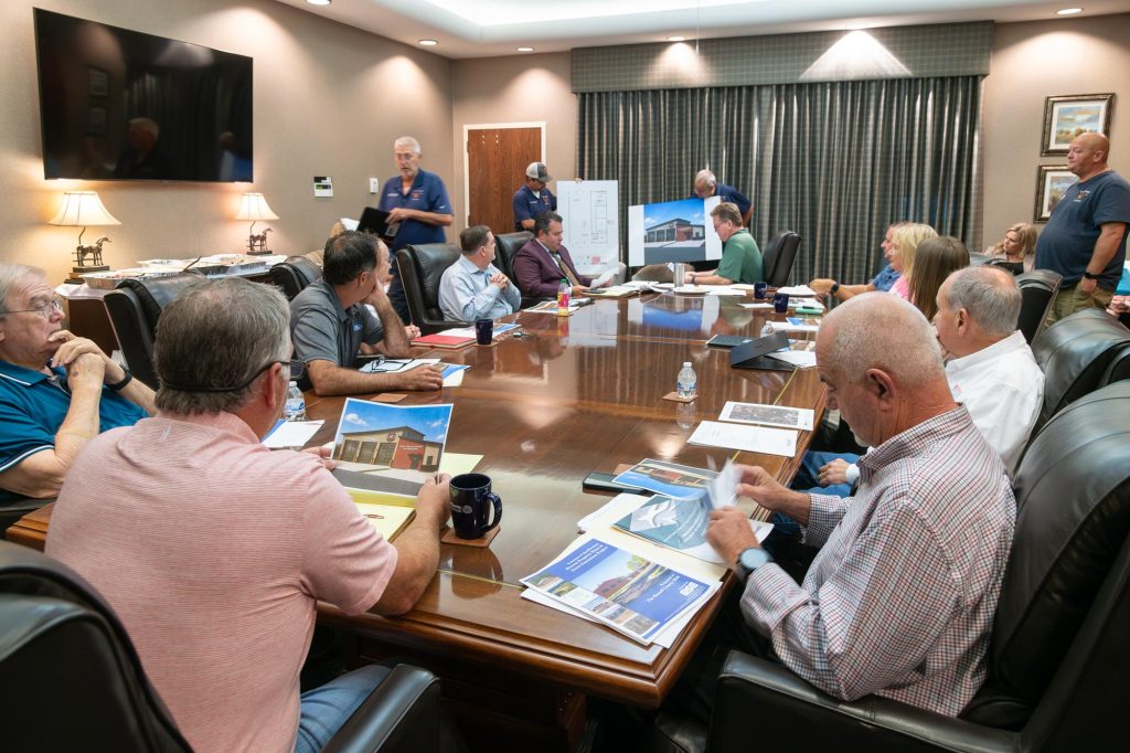 People in board meeting looking at plans and drawings